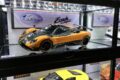 Pagani Zonda Cinque Coupe 1:18 model in orange and carbon, displayed in a lit collector cabinet