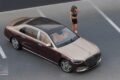 Mercedes-Maybach S-Class 1:18 model in Kalahari Gold over Rubellite Red, seen from above in a parking-lot diorama with a figure